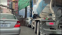 Cement mixer smashes into cars while trying to squeeze through narrow gap in Cambodia