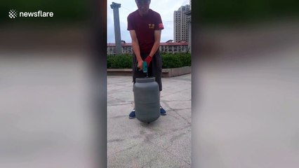Elderly Chinese man spins 15 kg gas canister using a drill