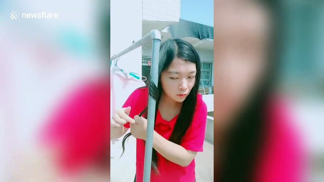 Chinese girl uses a hot outdoor water pipe to curl her hair