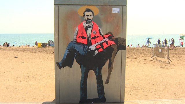 El artista urbano Tvboy pinta a Camps de Open Arms como un santo en la Barceloneta