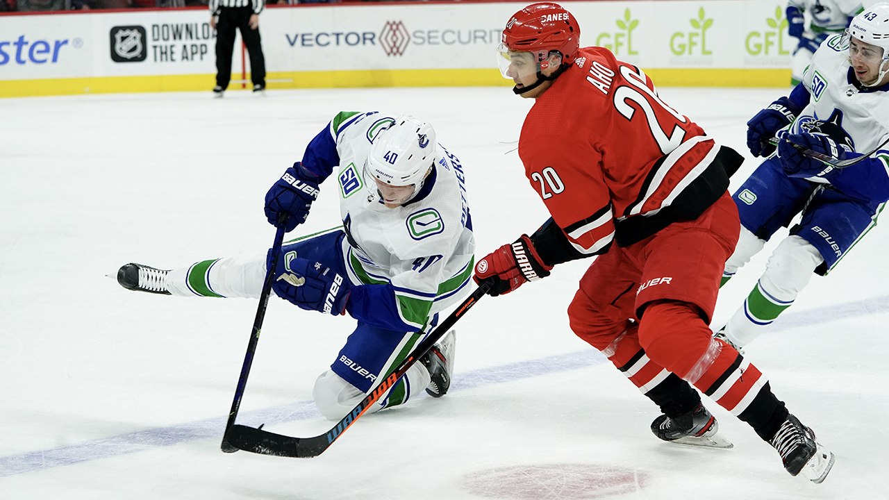 Elias Pettersson scores while falling to the ice