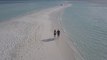 4k Couple Walking on a Beach Filmed with a Drone
