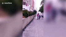Chinese mother and daughter walk on street covered in huge plastic bag amid coronavirus outbreak