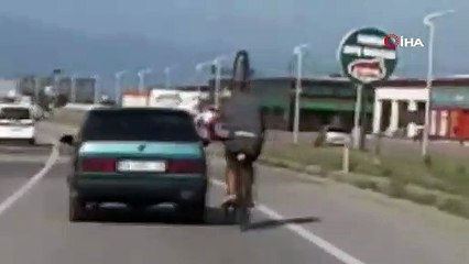 Bisikletiyle otomobile tutunan adam düştü: Korkutan anlar