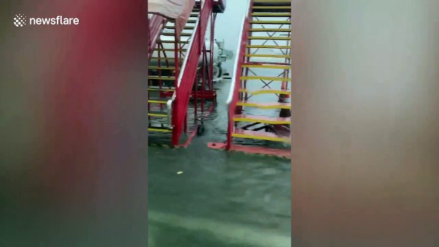 Airport bus drives passengers across flooded tarmac after tropical storm