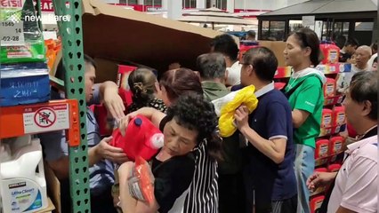Customers climb under store shutter as China's first Costco shop opens