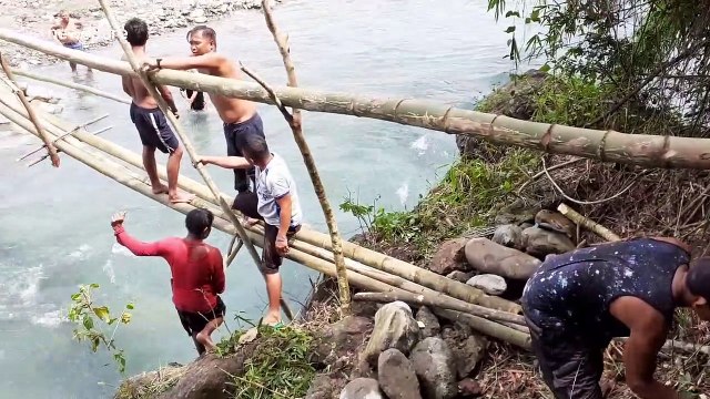 Villagers waiting six years for bridge to be finished make their own from bamboo