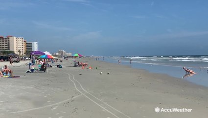 Folks put a hold on the storm preps to take in some sun, sand and a calming ocean