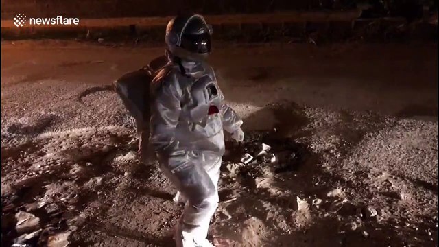 Indian artist pokes fun at potholes by dressing as an astronaut and 'moonwalking'