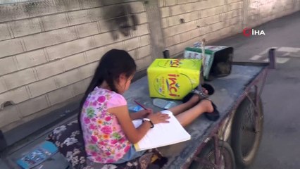 Babasının çöpten topladığı kitapları okuyor