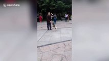 Elderly Chinese man ballroom dances with his dog