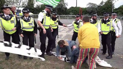 Police wrestle with protesters blocking trucks at DSEI arms fair in London