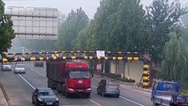 Car narrowly avoids being flattened by barrier knocked down by truck in China