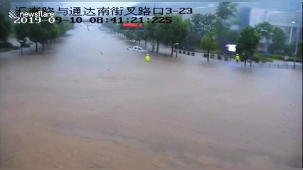 Chinese police officer kicks in truck windscreen to rescue driver trapped in floodwater