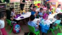 Okul müdürü çocuğa bakıyor, öğretmen de öğrencilere ders veriyor