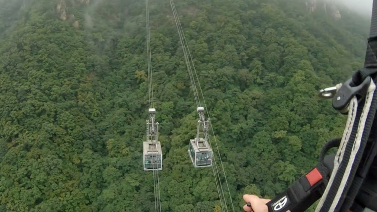Man Paramotors Right By A Cable Car