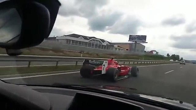 Un automobiliste se fait doubler par une Formule 1 sur l'autoroute