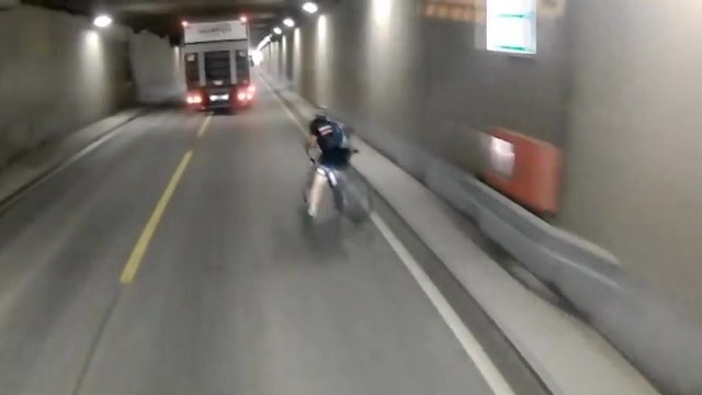 Un cycliste percute une barrière et tombe sur la route juste devant un camion