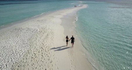 Couple Walking on a Beach Filmed with a Drone
