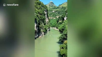 Locals paddle down Chinese river on single sticks of bamboo