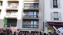 Elderly woman blows kisses to climate strikers marching below her balcony