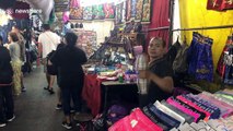 Market stall trader lifts dumbbells in between serving tourists in Thailand