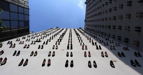 Un artiste turc accroche des escarpins sur la façade d'un mur d'Istanbul pour commémorer les 440 victimes de violences conjugales
