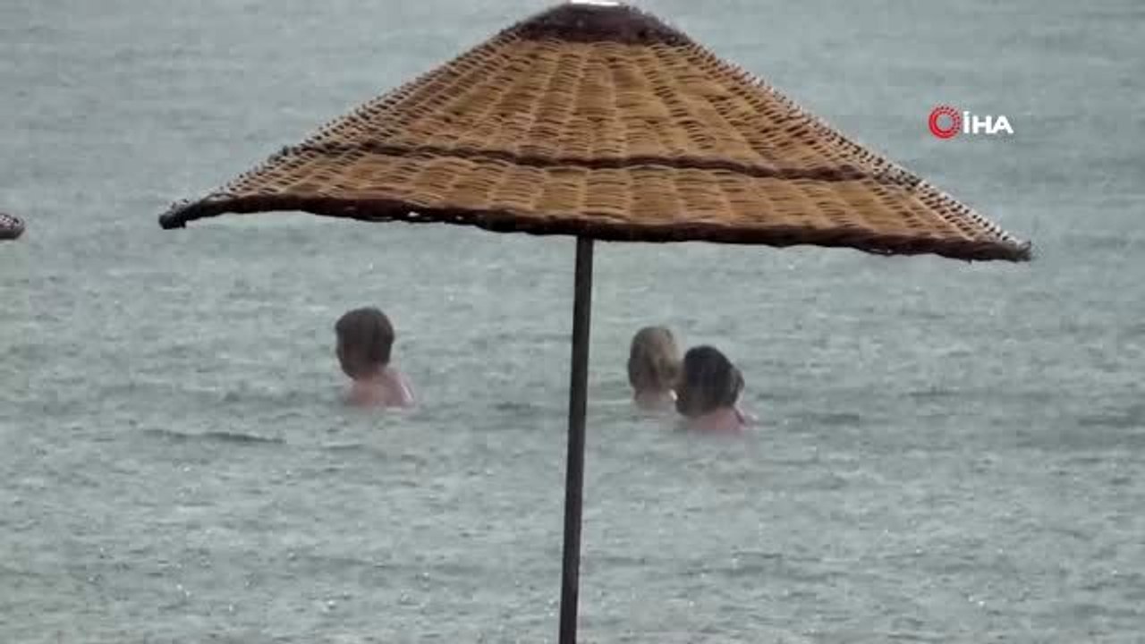 Yağmura aldırmayan turistler denizin keyfini çıkardı