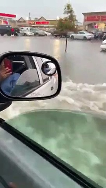 Il roule dans sa ville inondée au milieu des voitures noyées