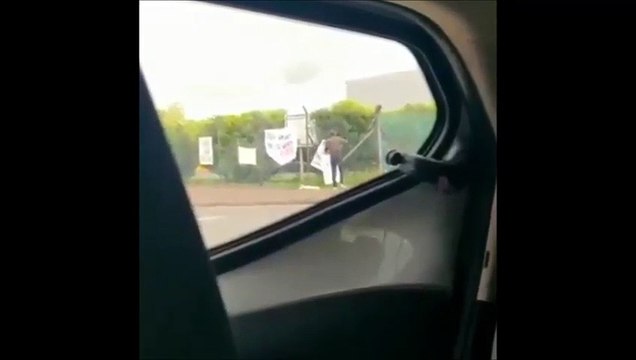 An unidentified man tears down signs and posters erected by former Wrightbus employees