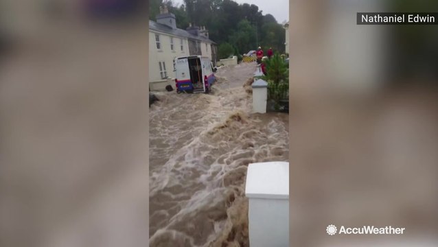 Floodwaters gush down road, sweeping away van