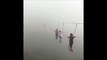 Ces touristes marchent sur un pont suspendu, perdu dans le brouillard... terrifiant