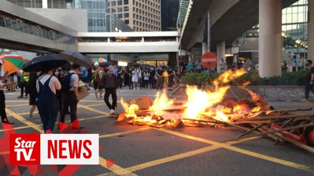 Protesters set fire to China anniversary banner in Hong Kong