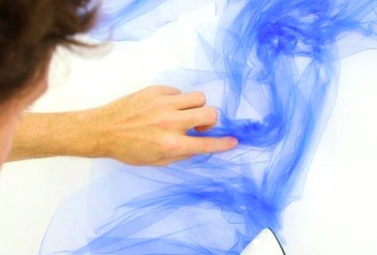 Artist irons face portraits out of fabric