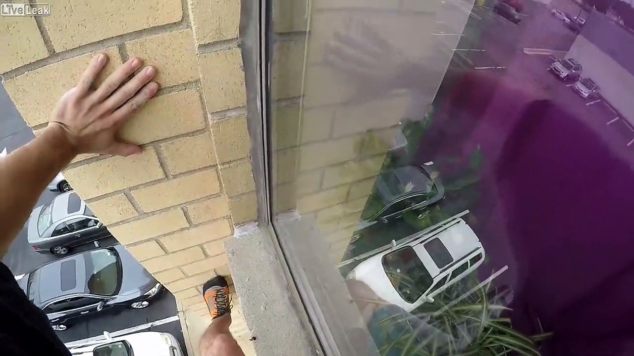 Il escalade un immeuble à mains nues par la façade