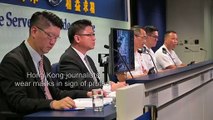 Hong Kong journalists wear masks at a police press conference