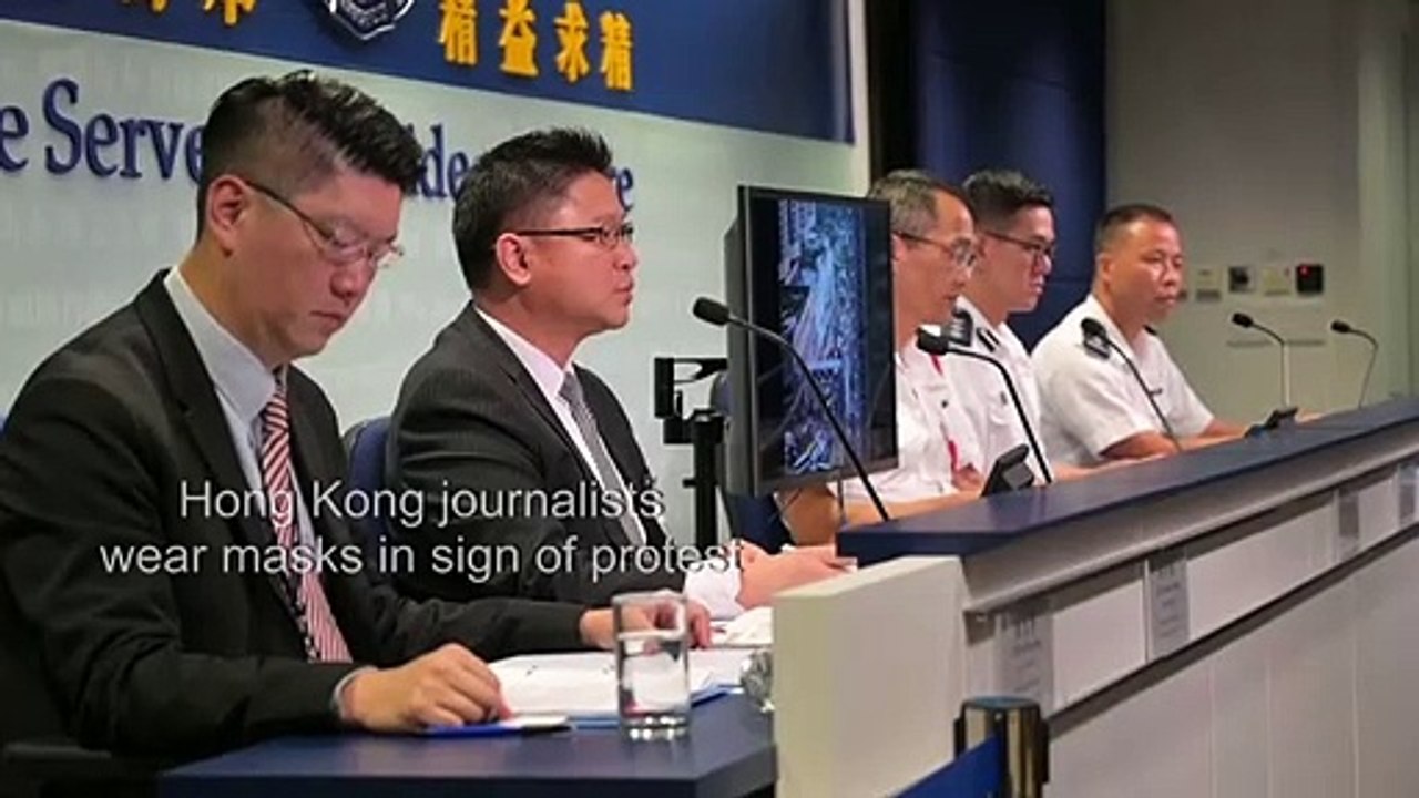 Hong Kong journalists wear masks at a police press conference