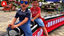 Les Enfants Jouent au Parc d'Attractions et Conduisent les Voitures