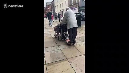 Adorable elderly couple cruise together on electric wheelchair hover-board hack