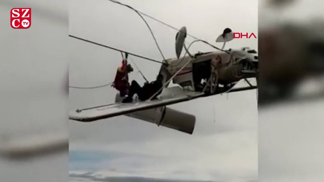 Uçak elektrik tellerinde asılı kaldı, pilot kanada oturup kurtarılmayı bekledi