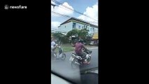 Relaxed motorcyclist stuns drivers by riding high speed while sitting cross-legged