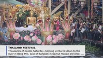 Devotees shower golden Buddha barge with lotus flowers at Thai festival