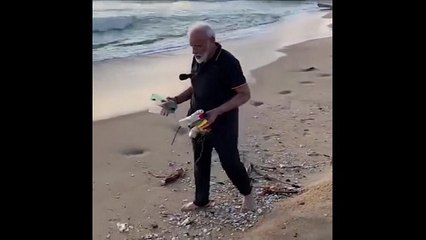 Modi da ejemplo y recoge plástico en la playa