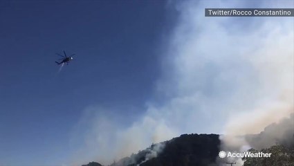 Smoke rises as a wildfire breaks out next to a highway