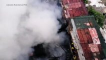 Billows of smoke engulf as firefighters extinguish the fire that razed houses in Paco, Manila