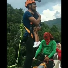 Un homme stupide fait un saut pendulaire avec sa fille dans ses bras