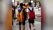 Una chica con bandera de España en Passeig de Gràcia y  un hombre se la intenta quitar