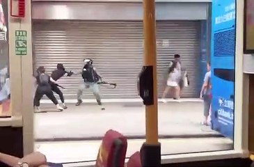 Un manifestant chinois frappe un policier et le projette au sol