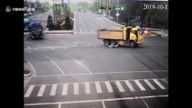 Chinese motorcyclist avoids serious injury after running red light and being dragged under truck
