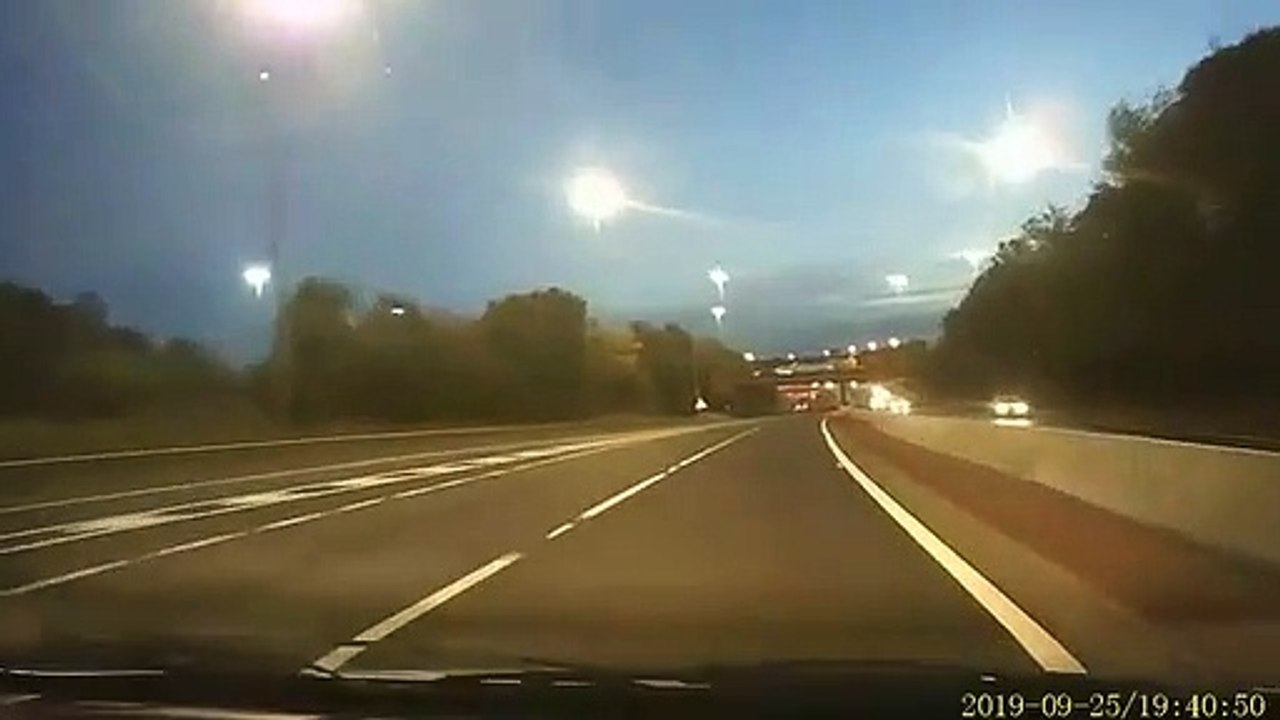 Un abruti balance une pierre d'un pont sur le pare-brise des voitures